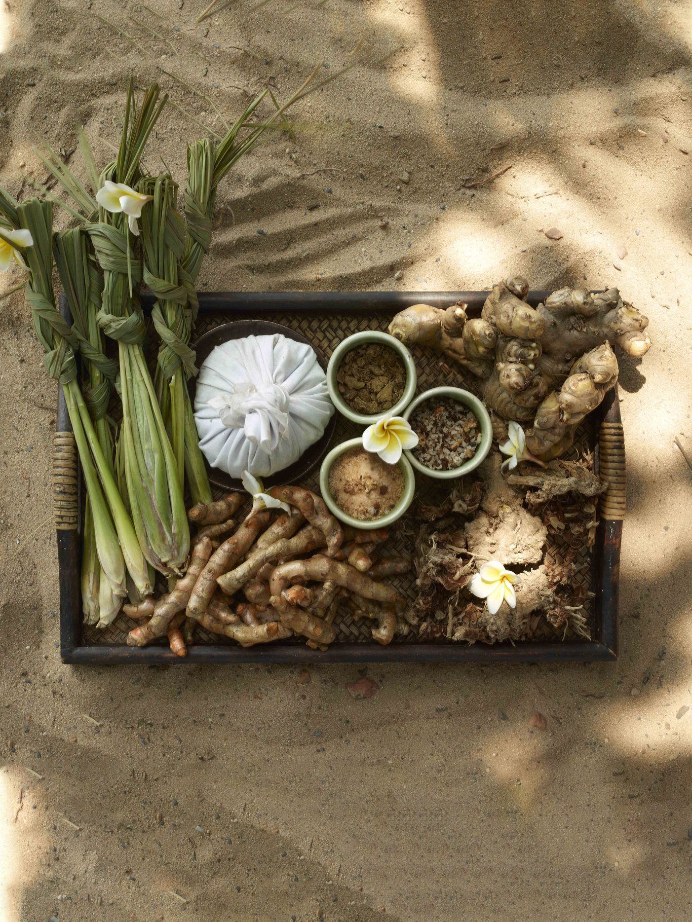 Lemongrass, turmeric, galangal and a herbal compress on a tray